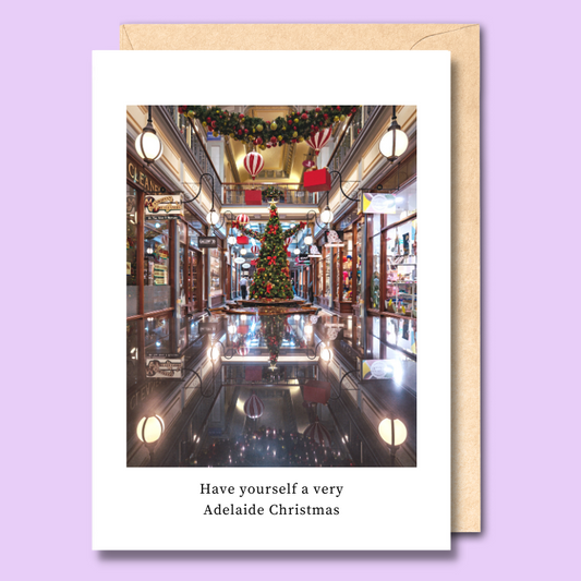 Greeting card with an image of Adelaide arcade reflected off of a wooden table on the front. The text says “Have yourself a very Adelaide Christmas.”