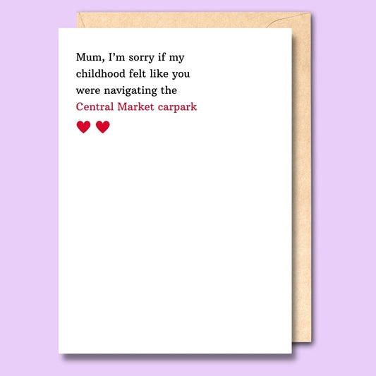A plain white card that says "I'm sorry if my childhood felt like you were navigating the Central Market carpark" on the front.