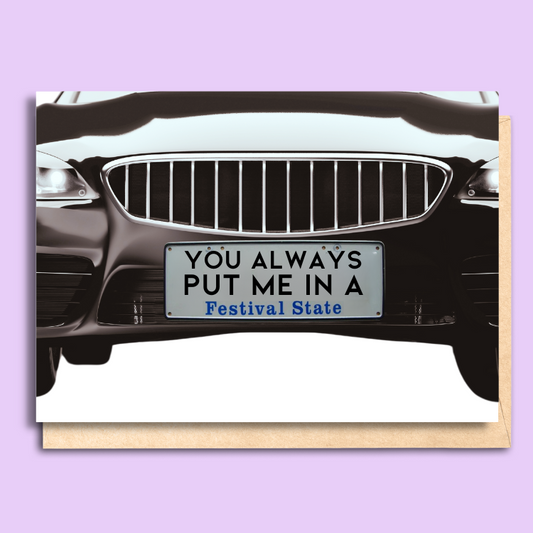 A zoom in of the front of a black car on a white card. The car goes right to the edge of the page. There is a South Australian style number plate in the middle that says 'you always put me in a Festival State'.
