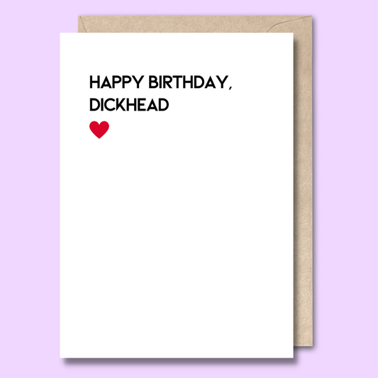 Greeting card with white background and text that says “Happy birthday, dickhead” followed by a red heart. 
