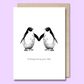 Front of a plain white greeting card with two penguins facing each other with their wings touching. The text below the image says "I’ll always be by your side."