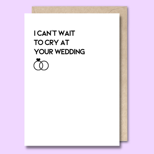 Greeting card with white background and text that says “I can’t wait to cry at your wedding” followed by two small black rings. 