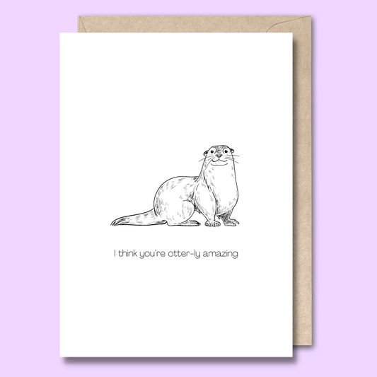 Front of a plain white greeting card with a black and white sketch of a smiling otter in the middle. The text says "I think you're otterly amazing"