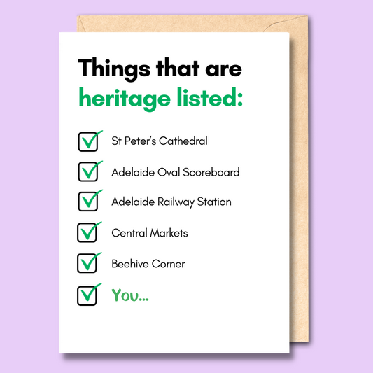 A plain white greeting card with a heading saying 'Things that are heritage listed'. Below that is a checkbox list of famous Adelaide landmarks including St Peter's Cathedral, the Adelaide Oval scoreboard, Central Markets and Beehive Corner. At the bottom of the list it says 'You' in bold.