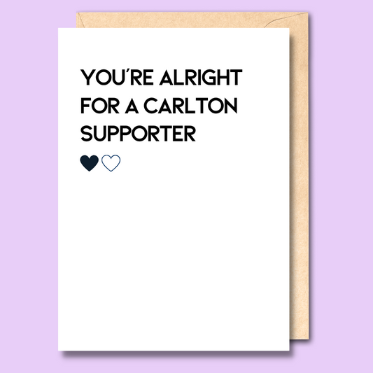 A white greeting card that says 'You're alright for a Carlton supporter' on the front.