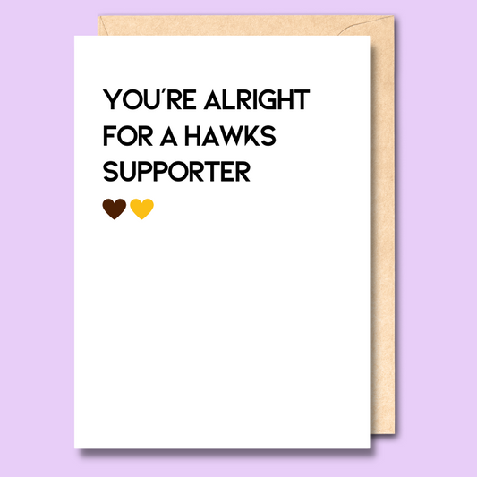 A white greeting card that says 'You're alright for a Hawks supporter'
