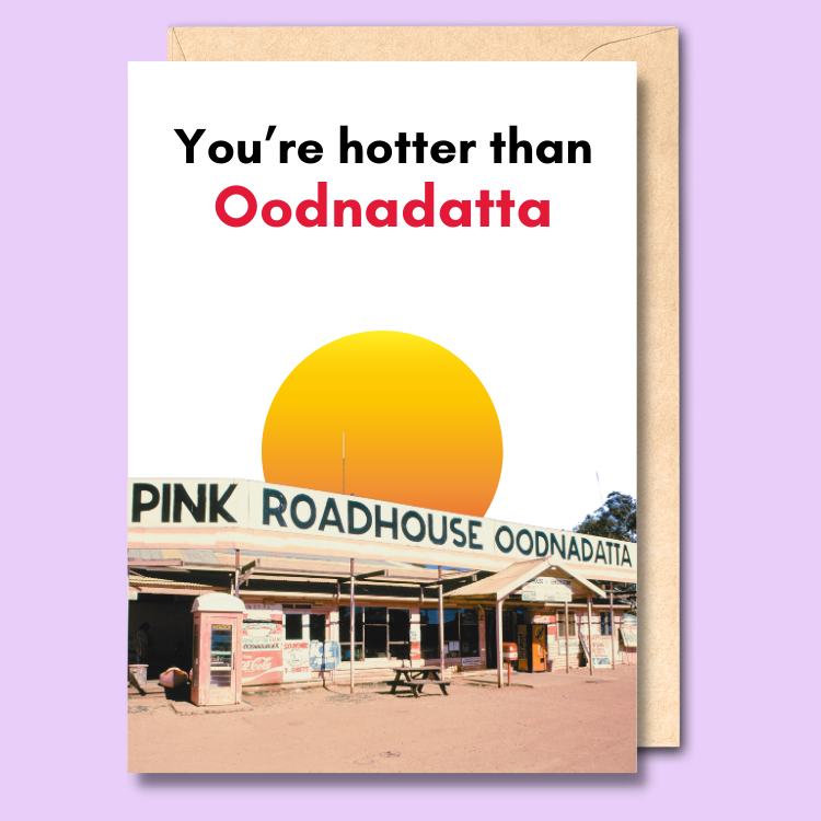 A white greeting card with a photo of the pink roadhouse in Oodnadatta on it. The text on the front says "You're hotter than Oodnadatta".